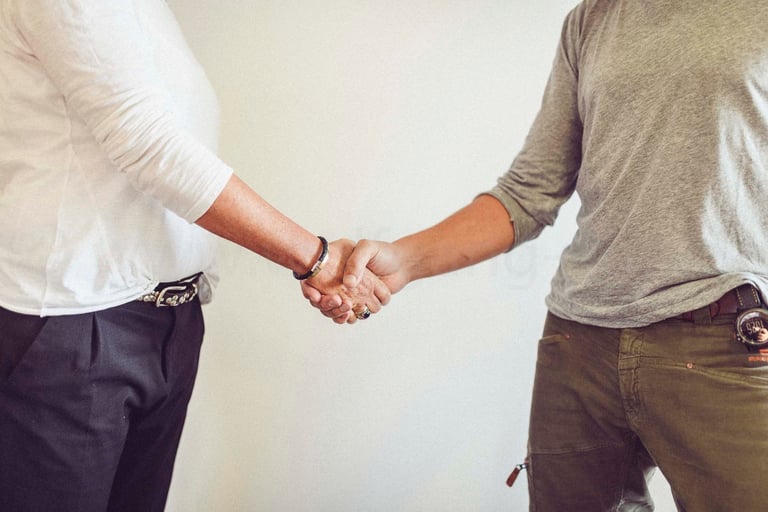two men shaking hands with a woman in a white shirt