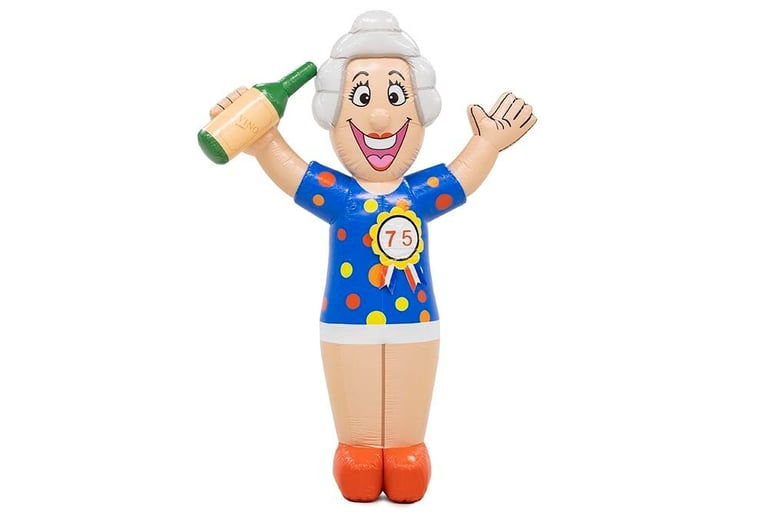 Lachende Sarah pop met blauwe jurk met stippen, grijs haar, rode schoenen met fles wijn in haar hand