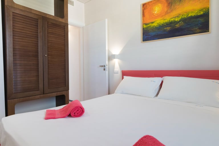 a bedroom with a bed and a painting on the wall