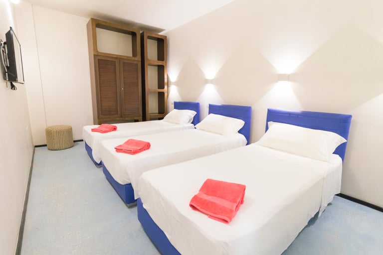 a bedroom with three beds and a television