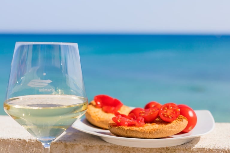 a glass of wine and bread with tomatoes on a table