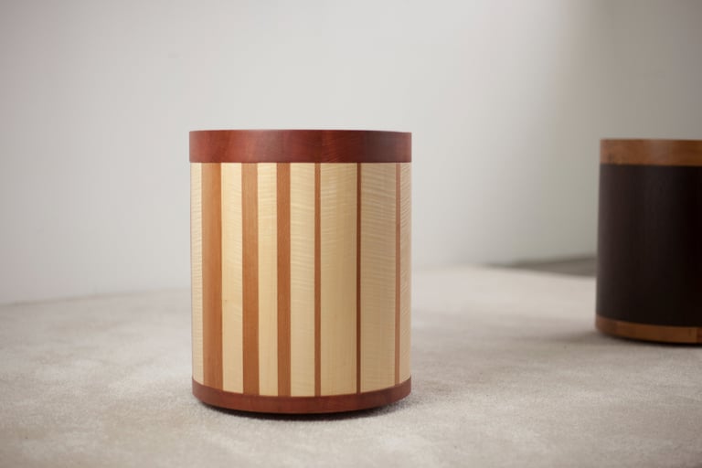 tabouret mobile plaqué de rayures irrégulières avec en arrière-plan un autre tabouret en bois sombre