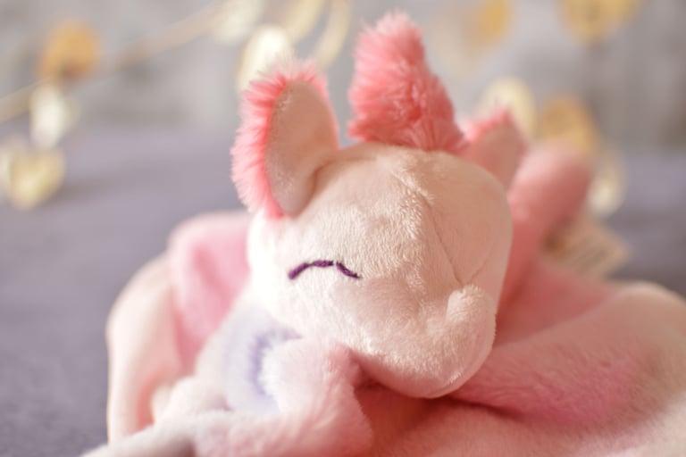 Gros plan sur la couture et le tissu d’un doudou artisanal, texture douce et souple.