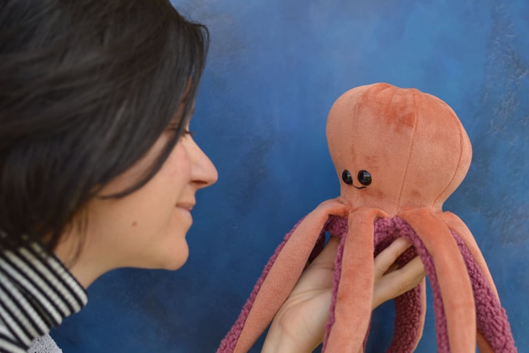 Créatrice tenant une peluche pieuvre artisanale saumon