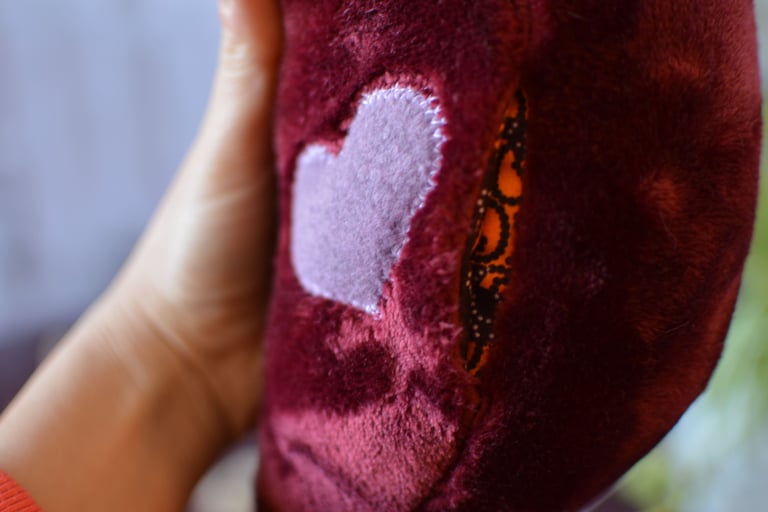 Détail de la poche sous le cœur d’une peluche amour cousu artisanale