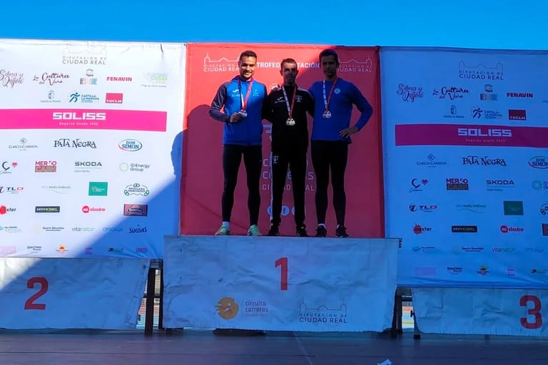 three men standing on a stage with medals