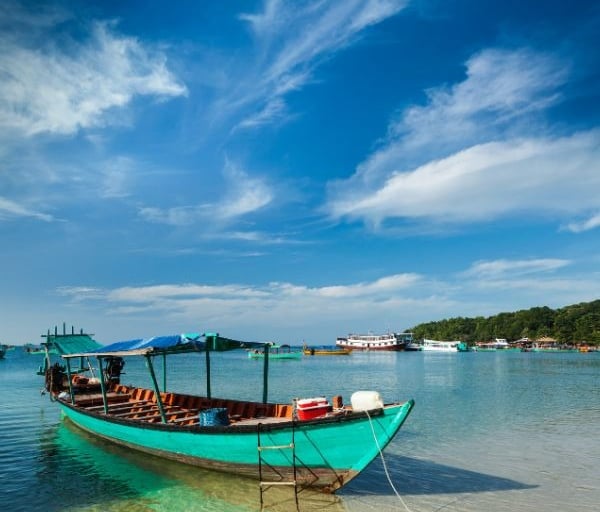 alt="Barco ancorado em praia de Sihanoukville, Camboja, escala em cruzeiros pela Ásia