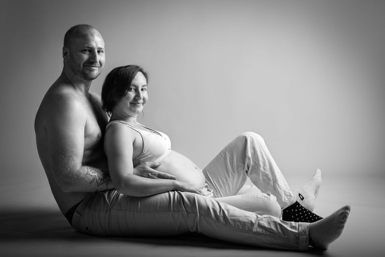 Portrait d'un couple assis au sol avec femme enceinte