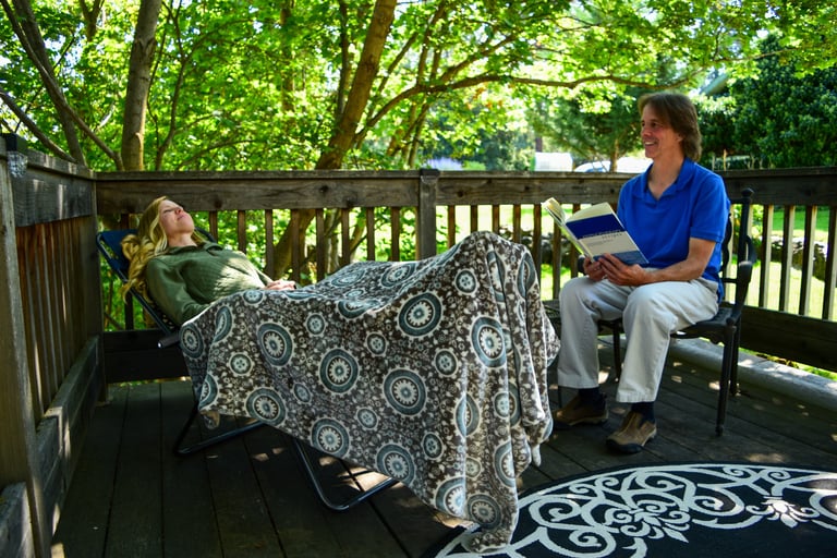 woman in hypnotherapy session with male practitioner on an outside deck