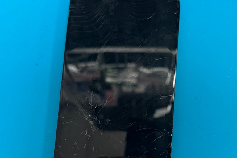 Cracked iPhone screen on repair workbench