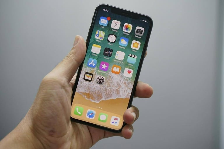 iPhone home screen held in hand