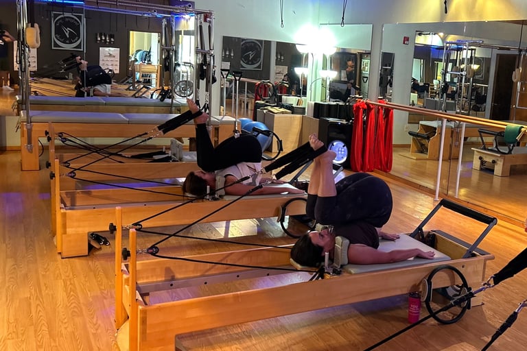two women working out on pilates reformers