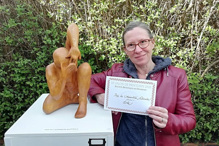 Lode posant à côté de sa sculpture Coquille, primée par l'Assemblée nationale au salon de Dourdan