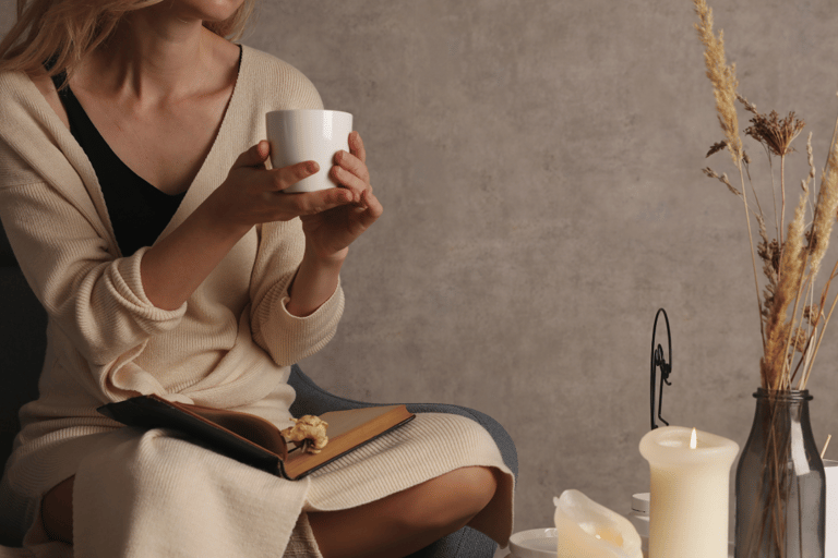 a woman sitting on a chair holding a cup of coffee