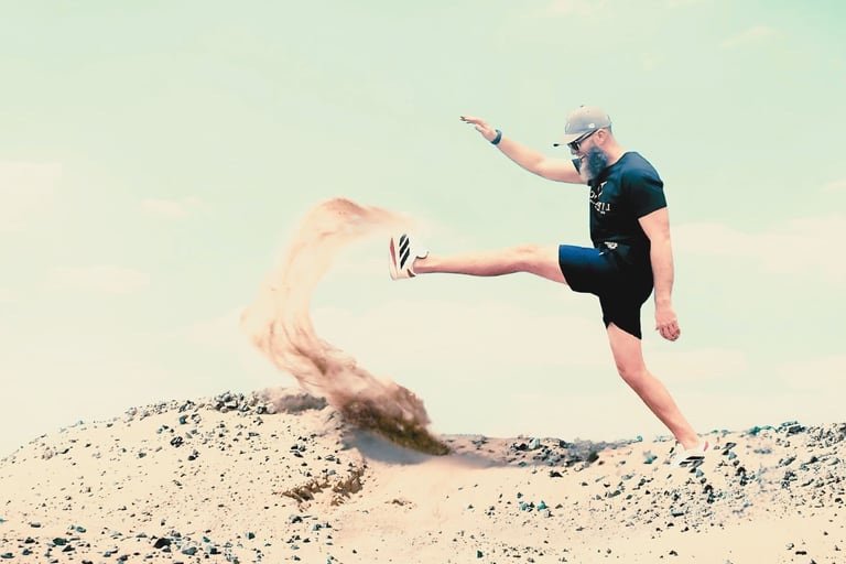 a man with a black shirt is kicking a sand