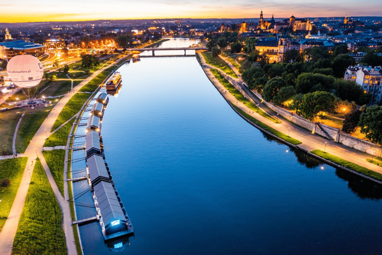 Aerial view of the Vistula River in Krakow at twilight with Wawel Castle and city lights.