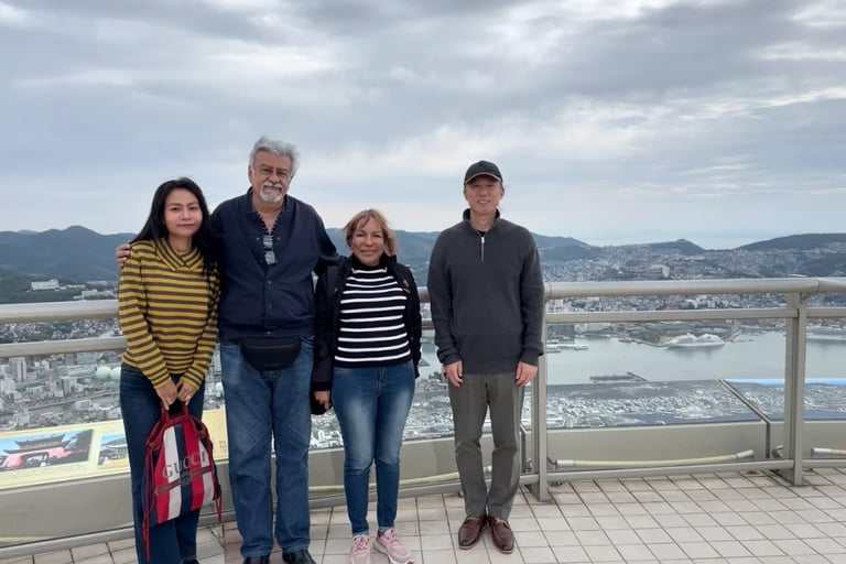 Two local guides and a couple taking a commemorative photo at the Mt. Inasa observation deck in Naga