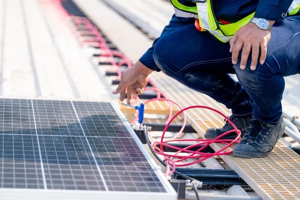 Hombre con pantalón de mezclilla azul y chaleco amarillo fosforescente realizando mantenimiento de p