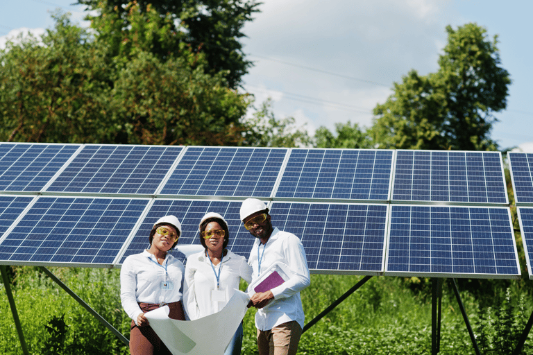 a group of people standing in front of a solar paneled solar array
