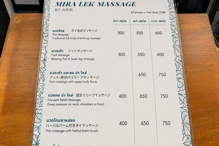 A Mira Lek Massage menu listing prices for Thai massage, foot massage, and oil massage services in Thai Baht.