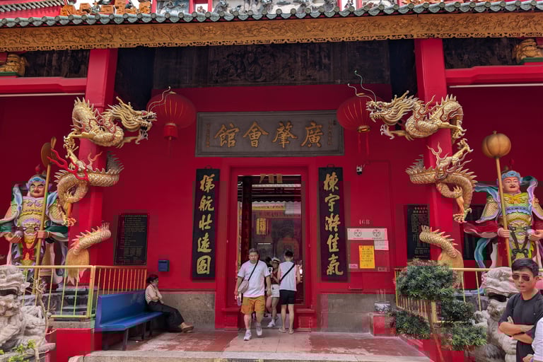 Ornate entrance of Guan Di temple in Kuala Lumpur with golden dragons and guardian statues.