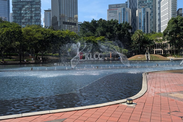 Symphony Lake fountain at KLCC Park with Kuala Lumpur city skyscrapers in the background.