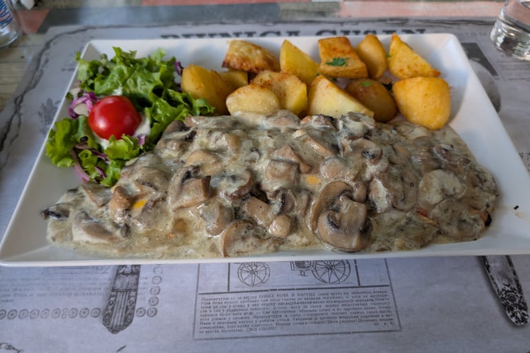 Delicious chicken smothered in mushoom, cheese with roasted potatoes, salad called Novi Sad Chicken 