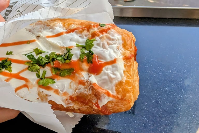 Pizza pastry filled with cured meats, tomaroes sause and cheese and topped with sour cream Belgrade