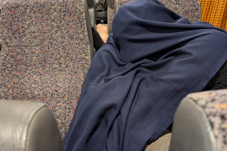 don sleeping under a blanket on the Blue star ferry from Thessaloniki to Lesbos Greece