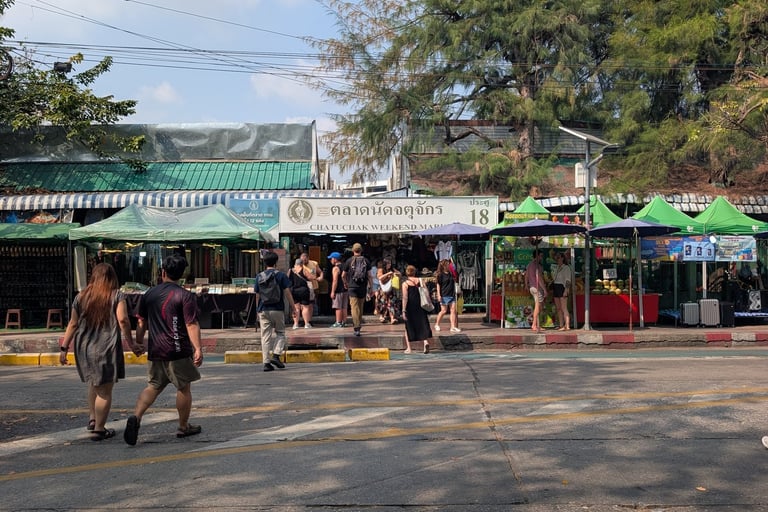 Tourists walking toward the entrance of Chatuchak Weekend Market in Bangkok, Thailand.