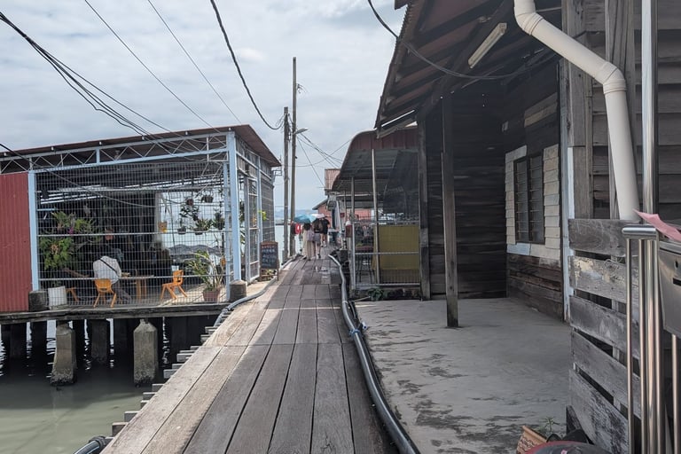 Rustic wooden walkway between stilt houses at Tan Jetty in Penang, Malaysia.