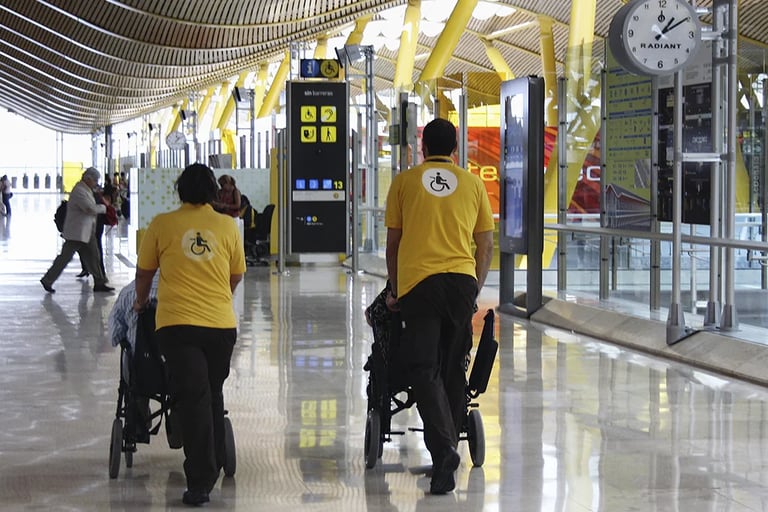 two people walking down a hallway with luggage