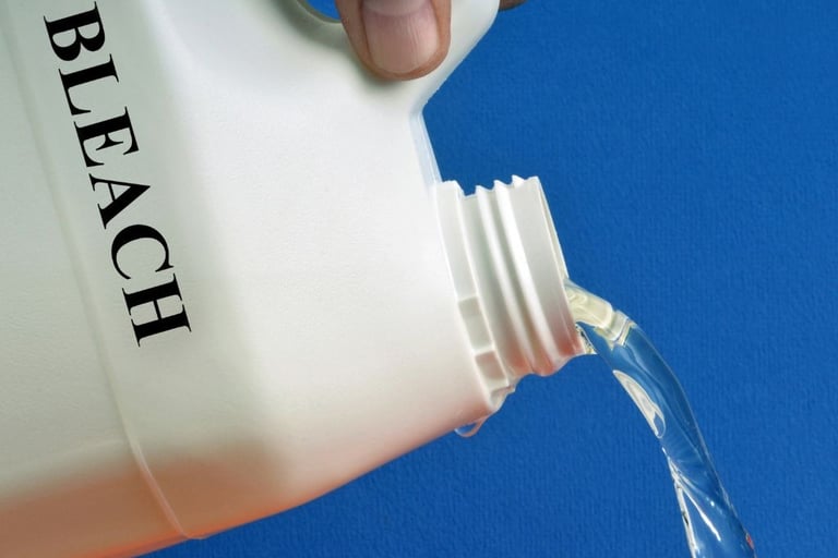 a person pouring a bottle of bleach