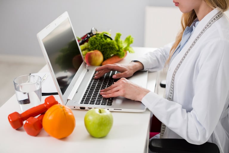 a woman in a lab coat is typing on her laptop