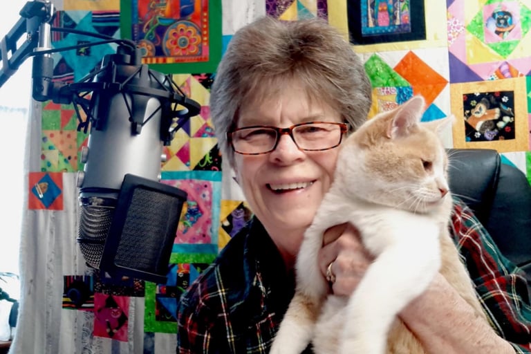 a woman in glasses and a plaid shirt is holding a cat