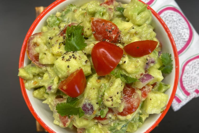 a bowl of guacamela with tomatoes and guacamole