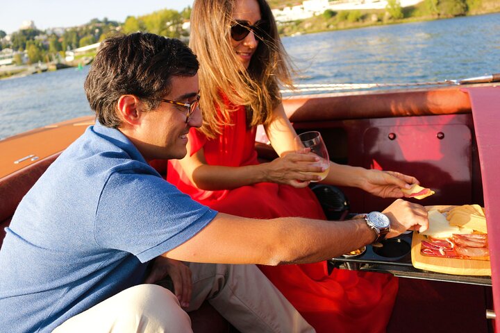 A couple enjoying wine and snacks on the James Bond–style speedboat Eskrok