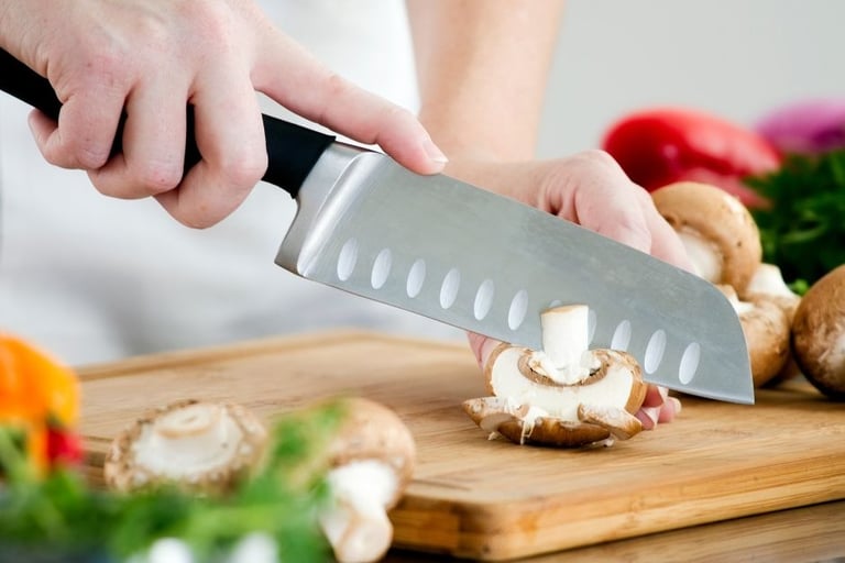 a person holding a knife and a knife in front of a cutting board