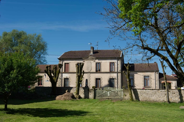 Gemeindehaus mit zwei Geschossen und links und rechts Anbauten.