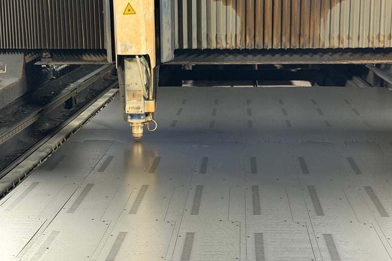 Large-scale fiber laser cutting machine in operation at ClaraTech factory for custom curved J-Curve monitor frames.