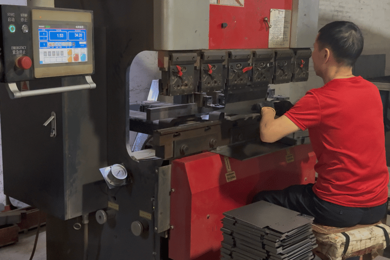 ClaraTech factory: Technicians using a bending machine for custom industrial monitor metal enclosures.