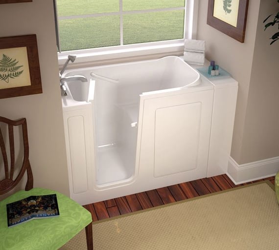 Compact white walk-in bathtub with easy-access door, built-in seat, and chrome faucet, installed by New Bath Elite in a brigh
