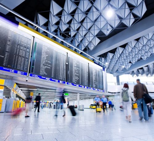 a group of people walking through a large airport