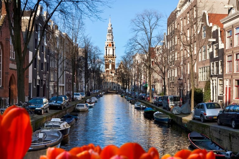 Amsterdam - a canal with boats and a church steeple