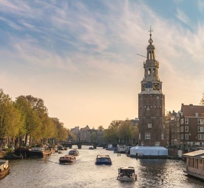 amsterdam - a river with boats and buildings in the background