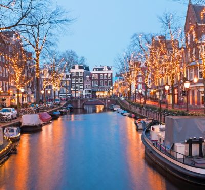 a canal with boats and christmas lights on it