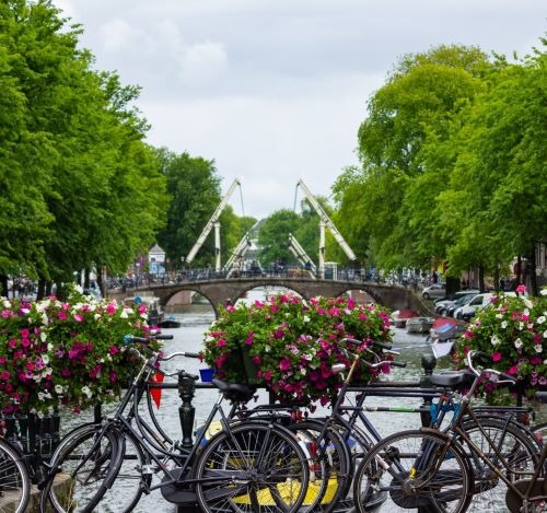 bicycles parked on a bridge over a river in amsterdam