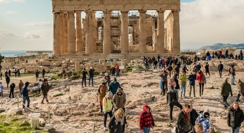 a group of people walking around a large stone structure