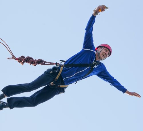 a man in a blue jacket is flying through the air