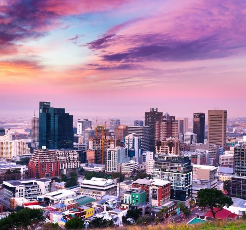 a city skyline with a sunset sky and a pink sky
